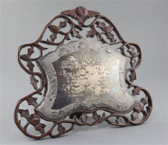 A mid 20th century Chinese white metal presentation plaque mounted on a pierced hardwood easel frame, width 32cm.
